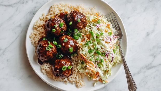 A clear glass bowl filled with a mix of three layers of shredded vegetables: bright green, thin broccoli stems, orange thin carrot strips, and some thin purple cabbage pieces evenly spread throughout. On top of these vegetables, there is a thick layer of creamy, light beige dressing placed in the center, slightly spreading out but not covering the outer vegetables. The bowl is on a white marbled surface. Photo taken with an iphone --ar 4:5 --v 7